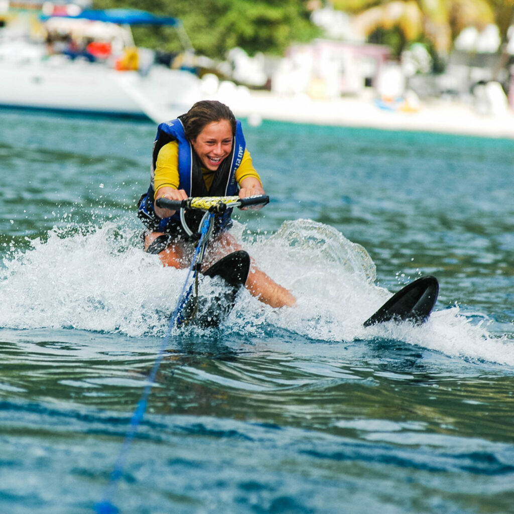 A girl is water skiing on a boat.