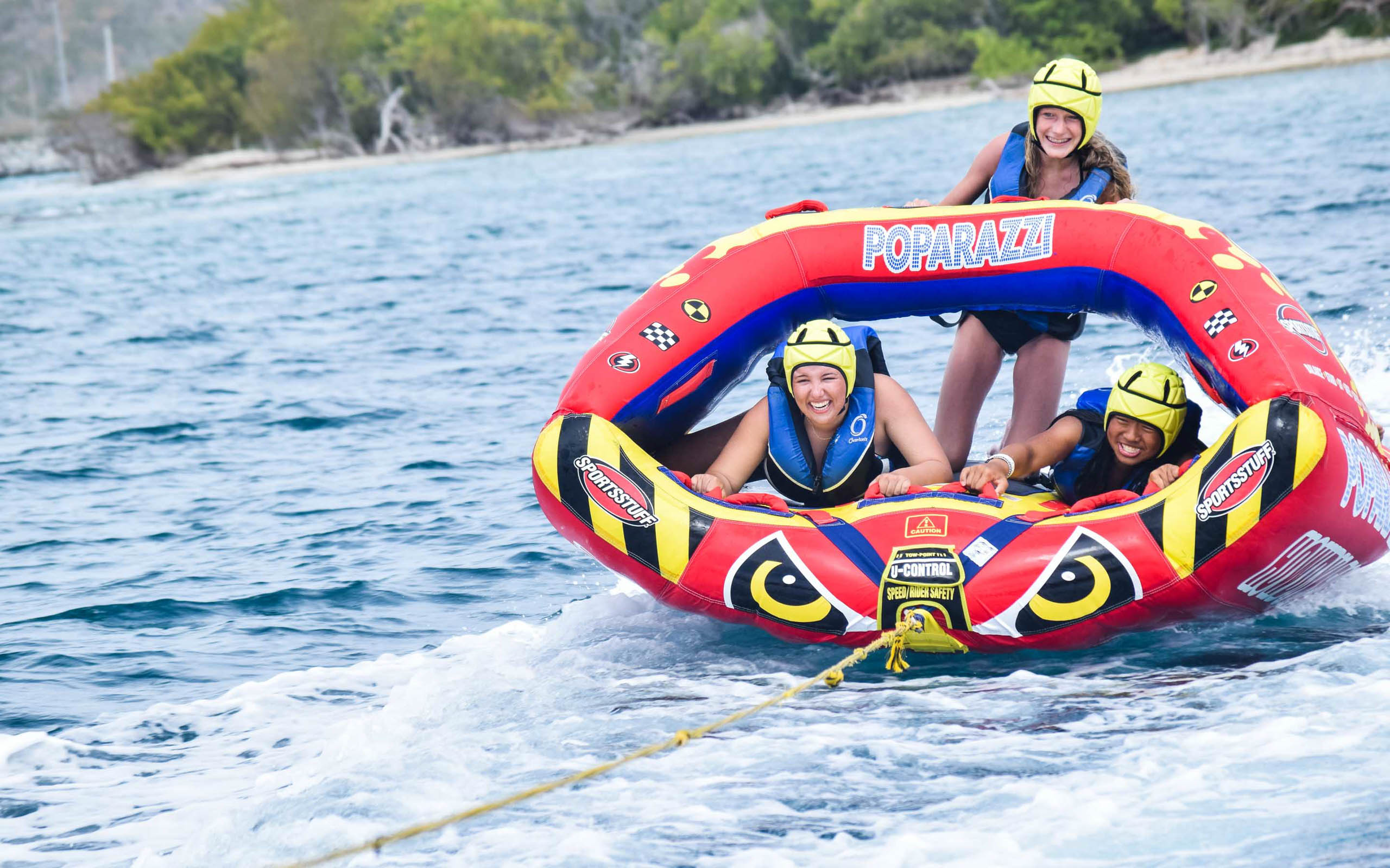 A group of people riding an inflatable raft in the water.