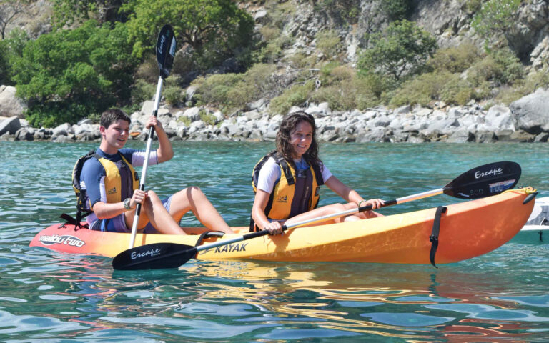 Two people paddling in a kayak on the water.