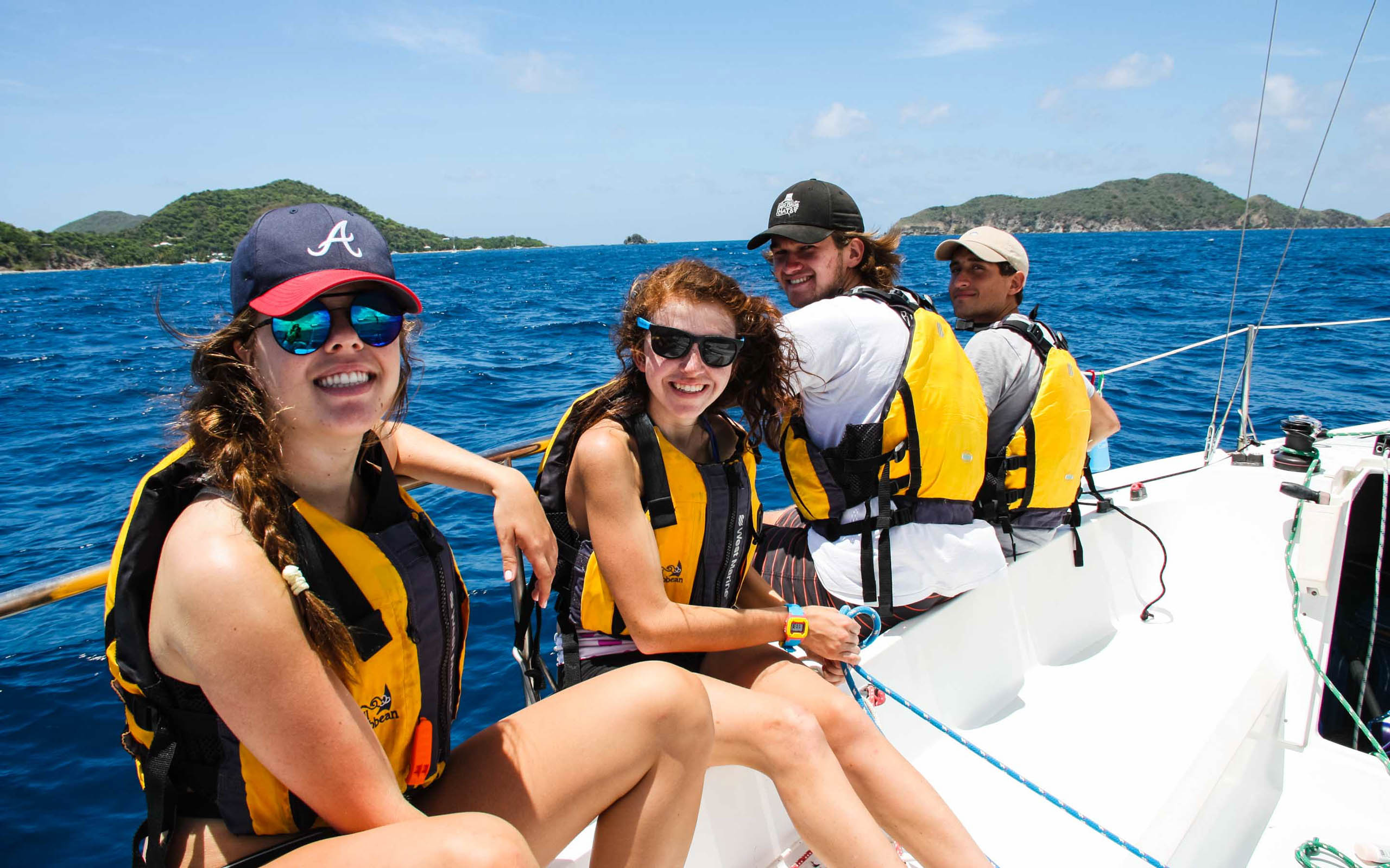 A group of people on a sailboat in the ocean.