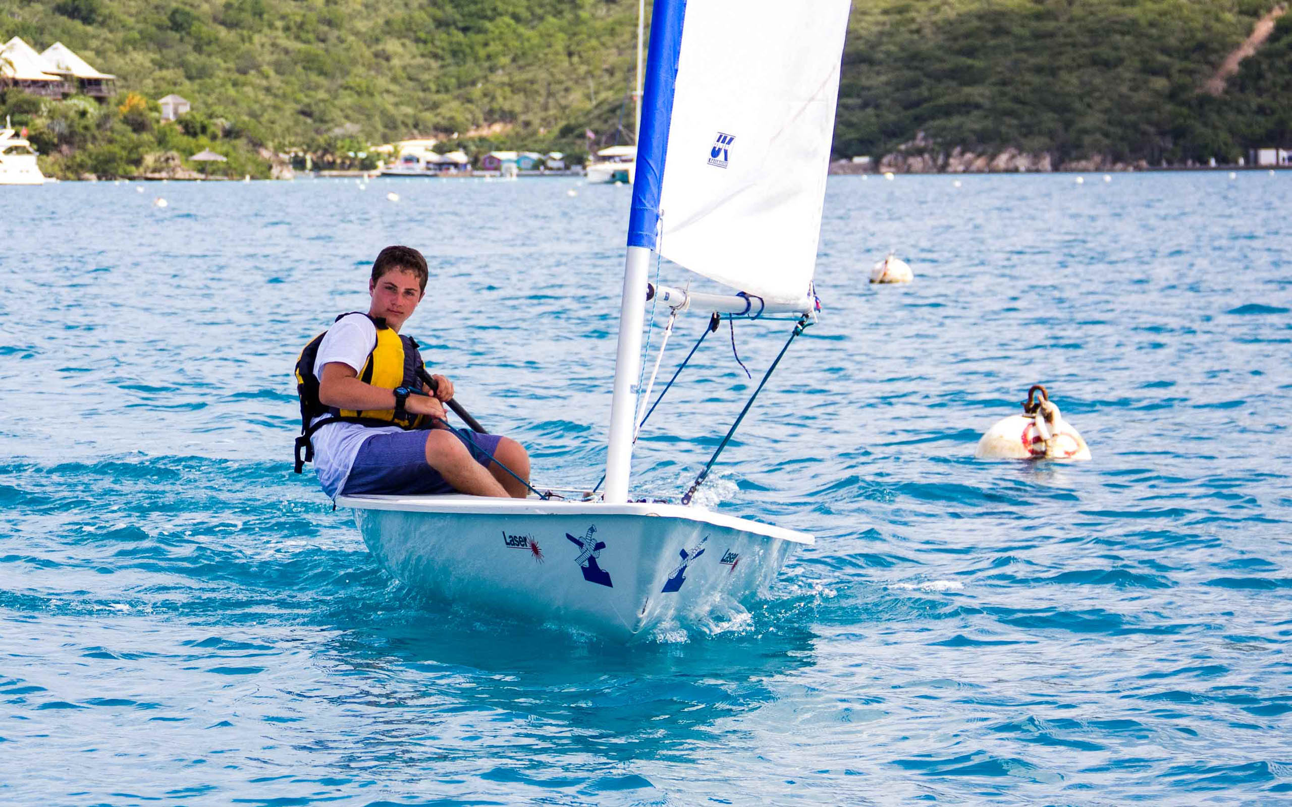 A man on a sailboat in the water.