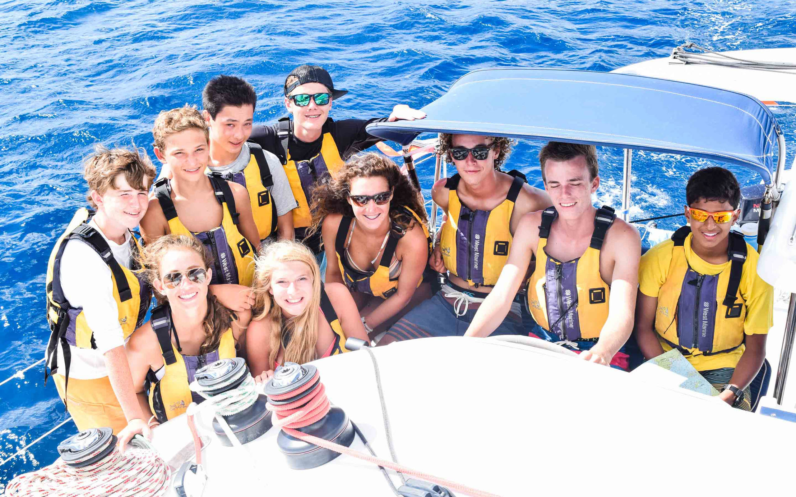 A group of people posing on a sailboat.