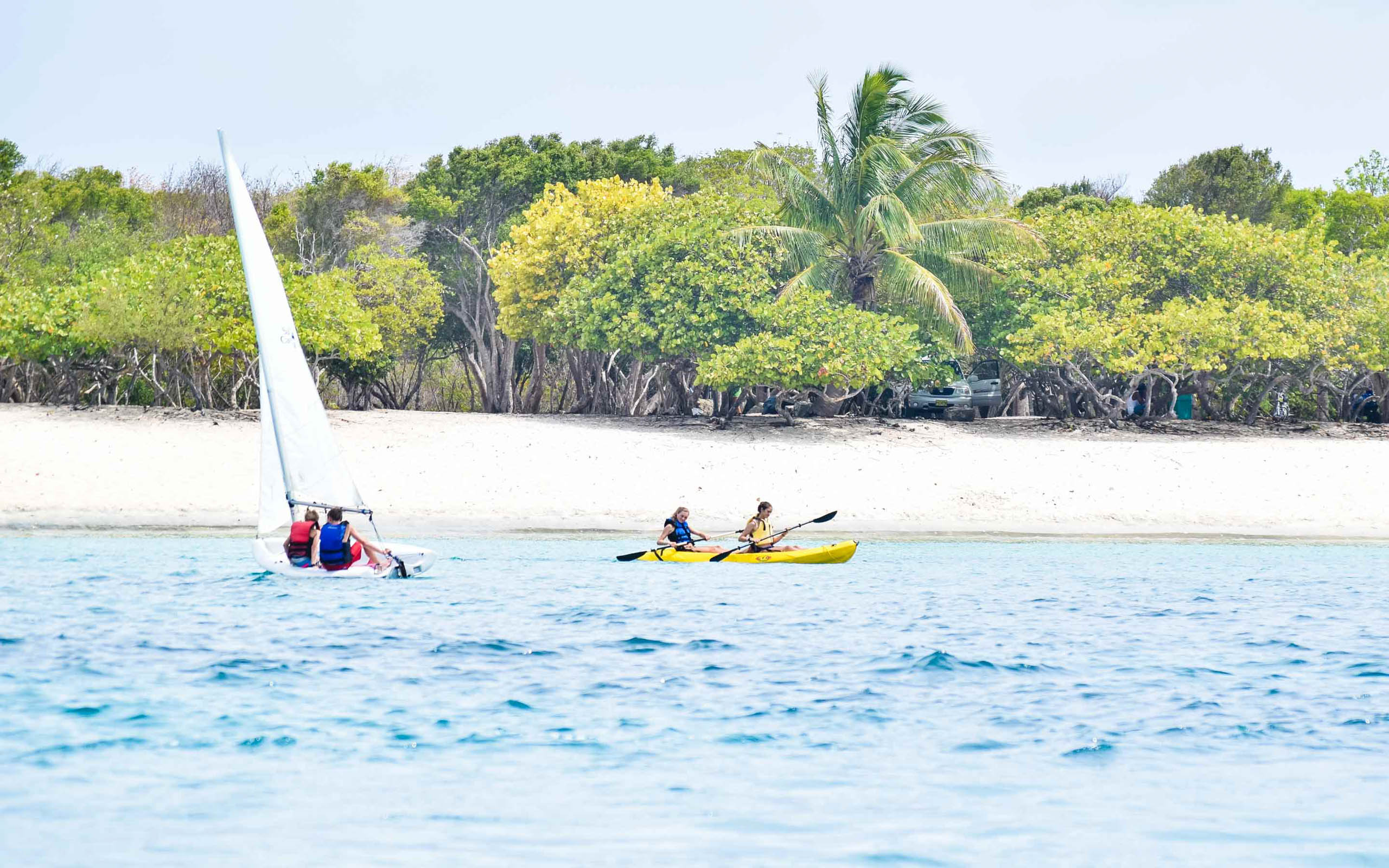 A group of people on a sailboat in the water.