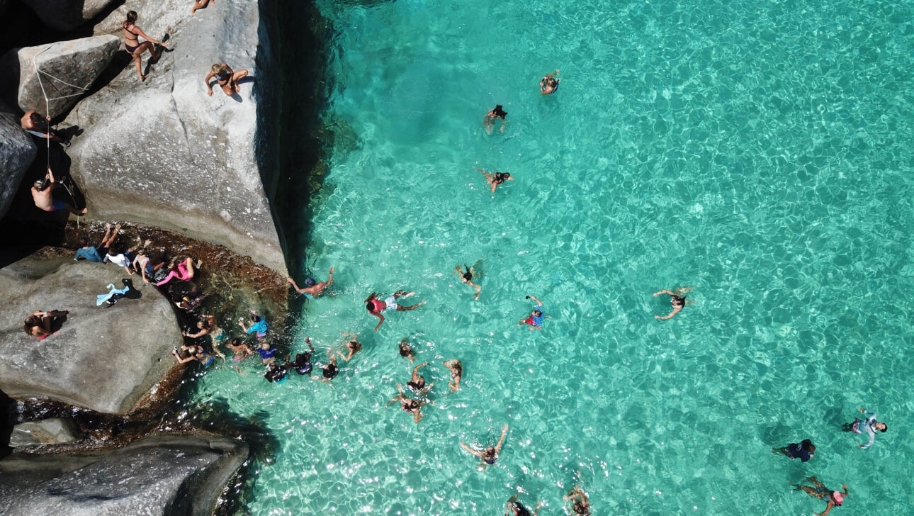 An aerial view of a group of people swimming in the water.
