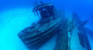 A boat is sitting on the bottom of the ocean.