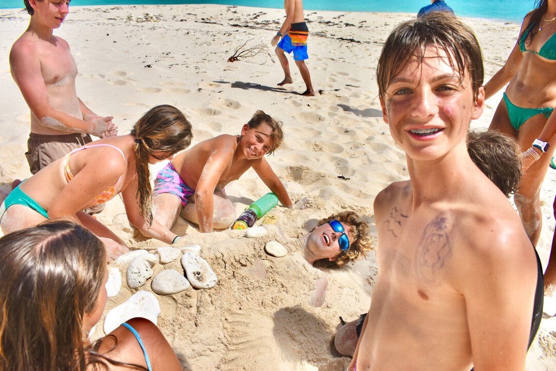 A group of people playing in the sand on a beach.